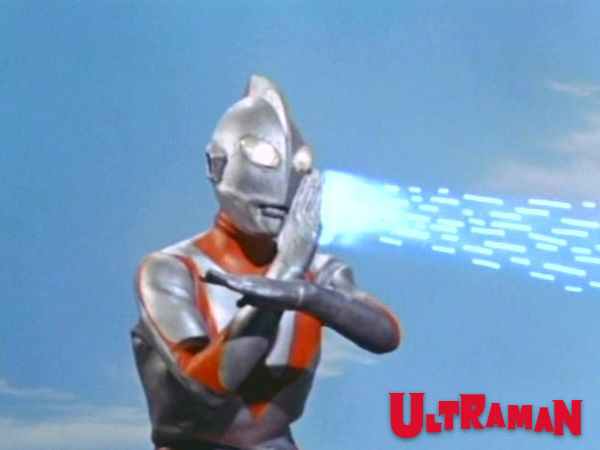 Cena do Ultraman, com os braços cruzados em frente ao corpo, em meio a efeitos visuais.