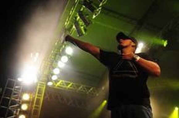 Digão, o vocalista dos Raimundos, de braço erguido no palco