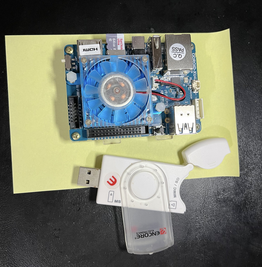 Placa Odroid XU4 ao lado de um adaptador para cartões de memória usado para gravar a sua imagem inicial