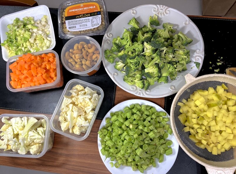 vegetais picados, ainda separados por tipo: cenoura, couve-flor, brocolis, vagem e batata. Mais amendoim e castanhas.