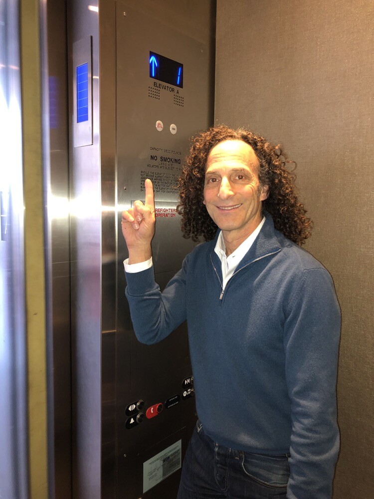 Kenny G sorridente em um elevador