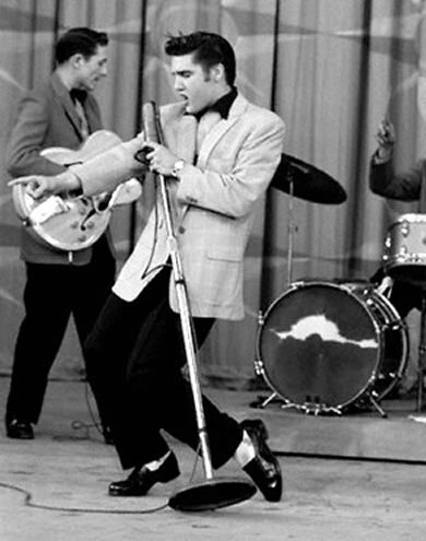 Foto em preto e branco de Elvis Presley dançando no palco