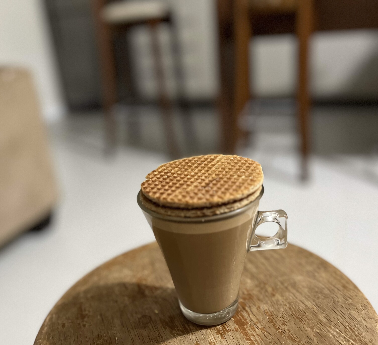 Xícara de café com leite eclipsada por 2 biscoitões