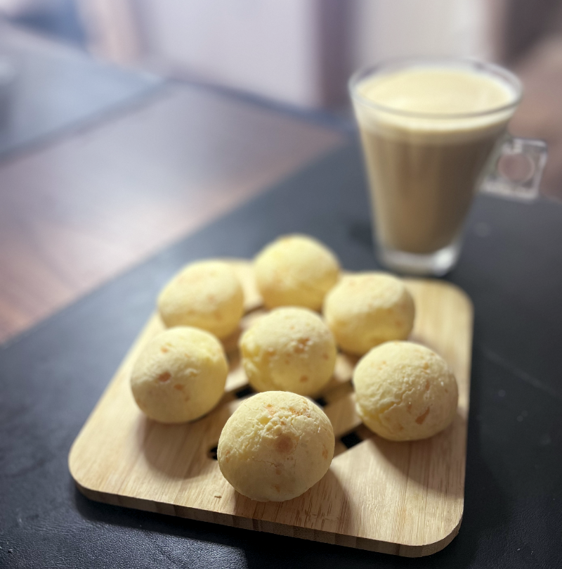 7 pães de queijo formando uma cadeia alicíclica, e uma xícara de café com leite