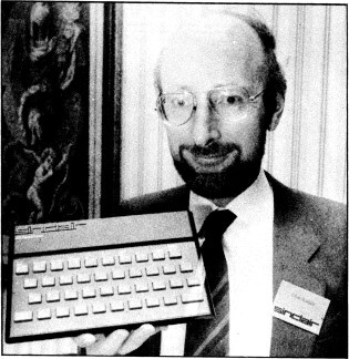 Foto em preto e branco de Sir Clive segurando um Sinclair ZX Spectrum, original que no Brasil virou o clone TK90X