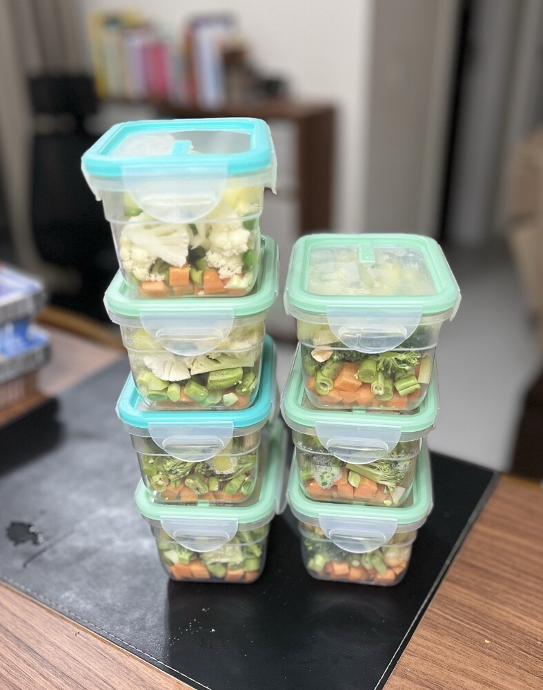 7 potes herméticos contendo porções individuais de mix de vegetais picados crus: cenoura, brócolis, couve-flor e vagem, mais batata e ervilha levemente fervidas, e um complemento de amendoim e castanha de caju