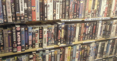 Fitas VHS em prateleiras de uma locadora