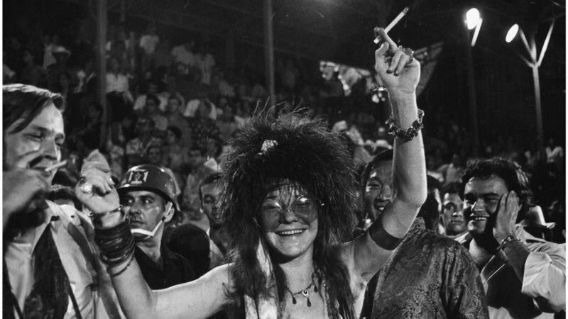 Janis Joplin sorri na arquibancada, assistindo ao desfile do carnaval de 1970, no Rio.