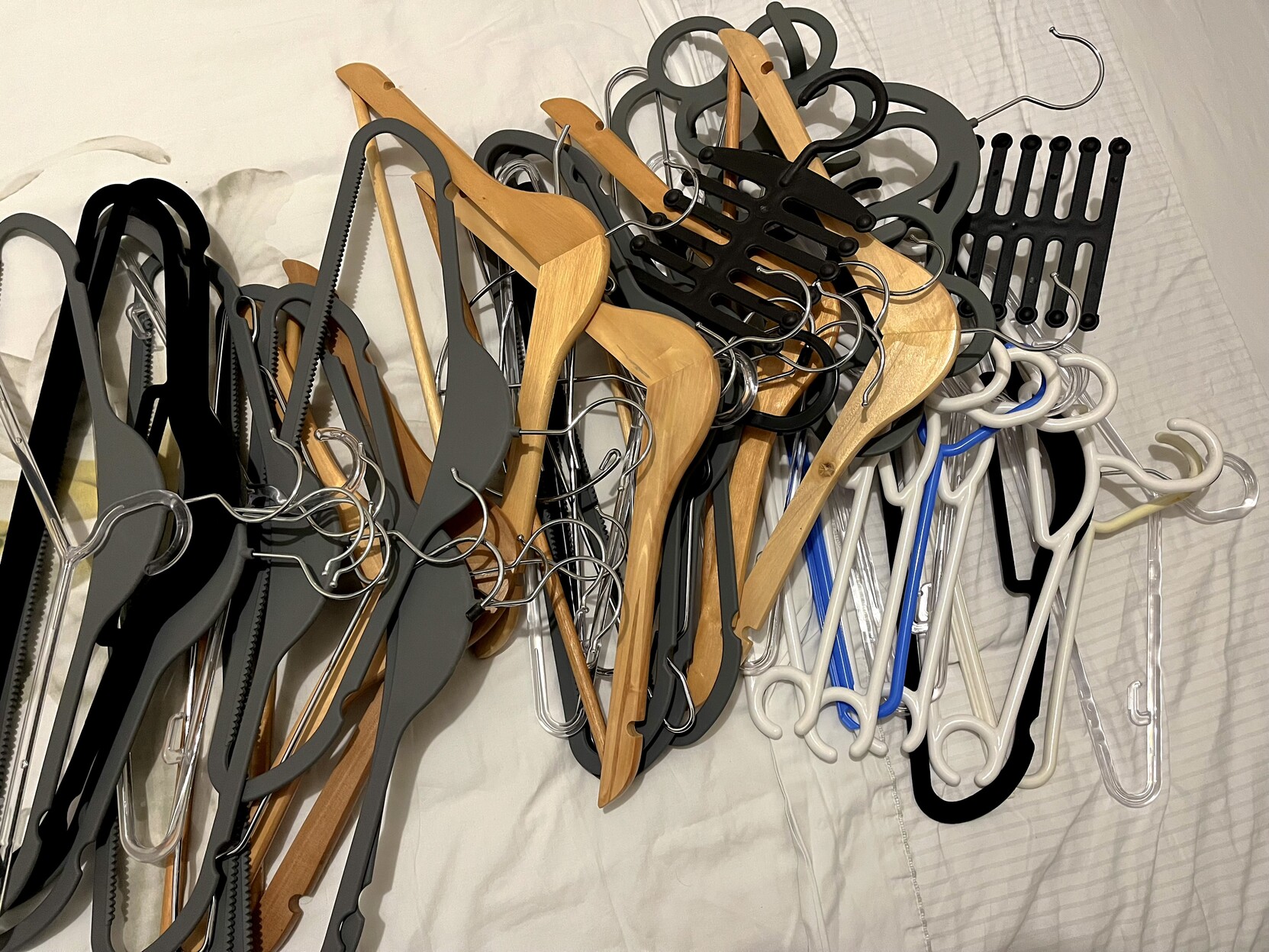 Dezenas de cabides, empilhados sobre a cama