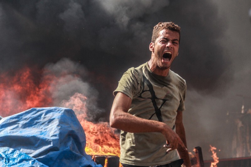 Manifestante grita em frente às chamas