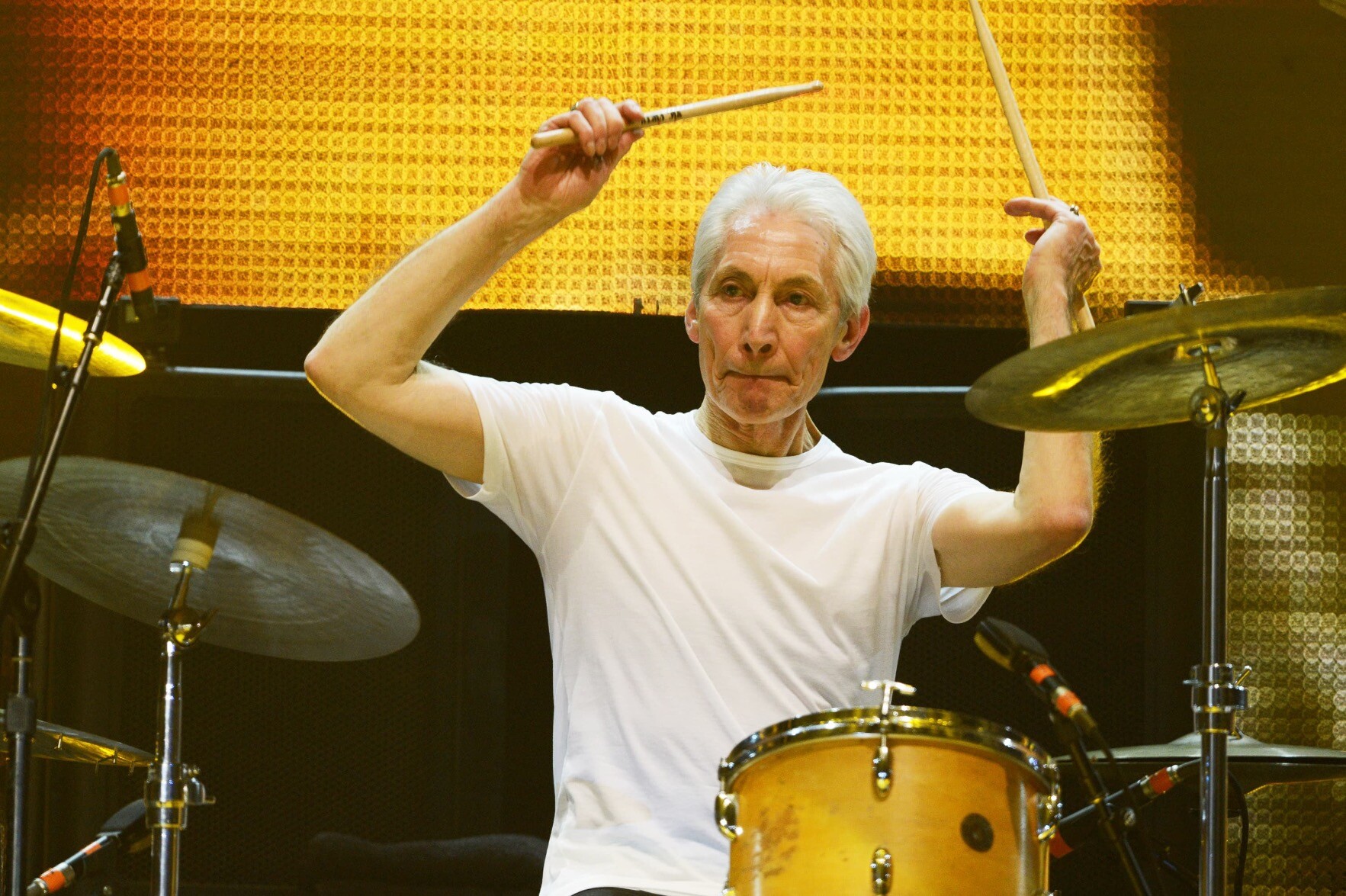 Charlie Watts no palco aponta para o alto com suas baquetas