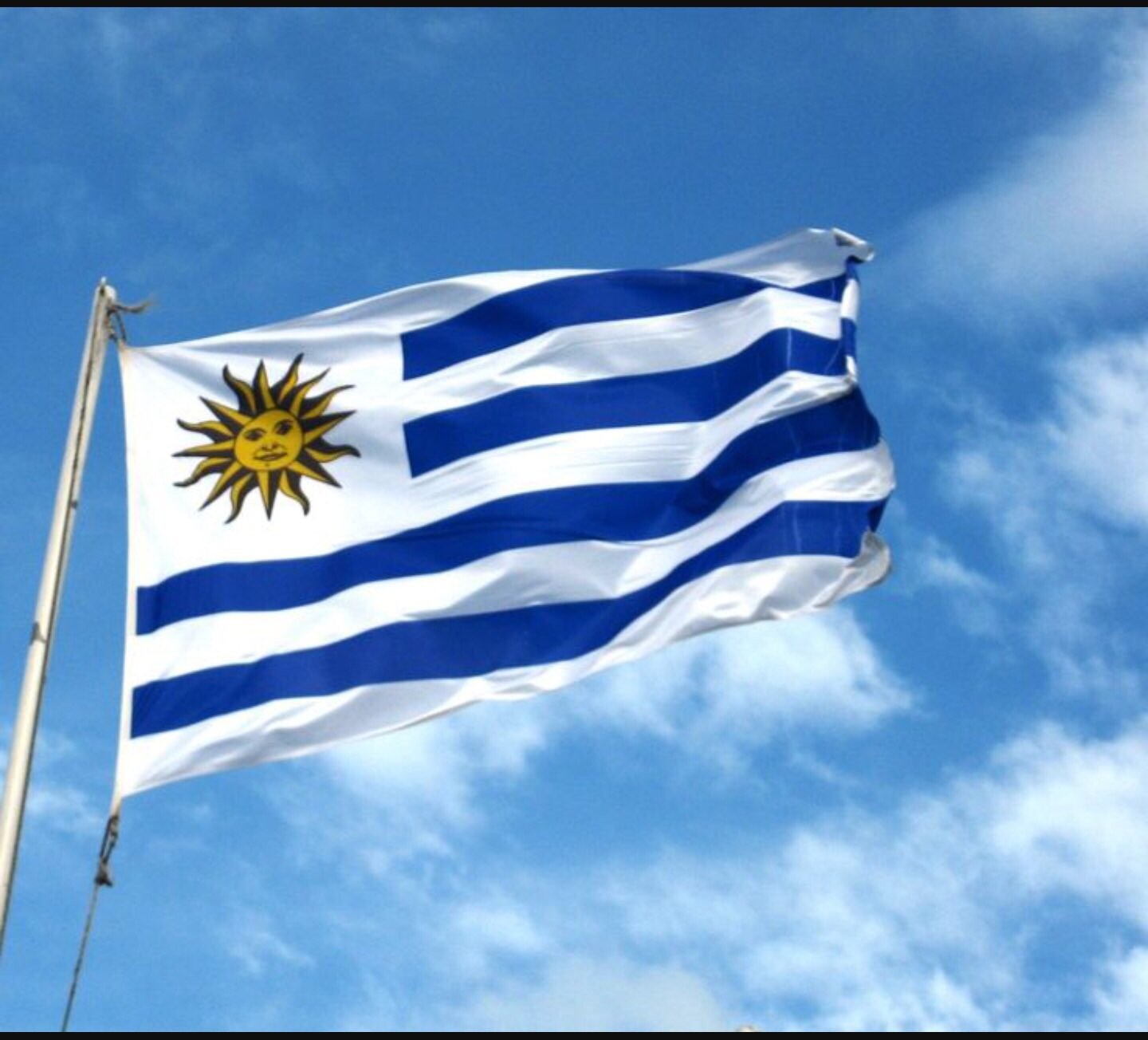 Bandeira do Uruguai tendo o céu azul como fundo