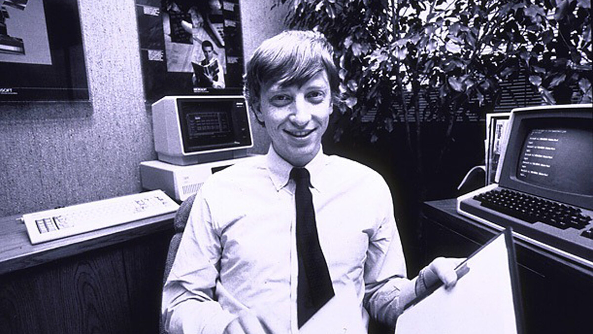 Foto em preto e branco de Bill Gates, com um IBM PC ao fundo