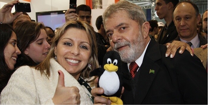 O Presidente Lula segura o Tux, mascote do Linux, em evento