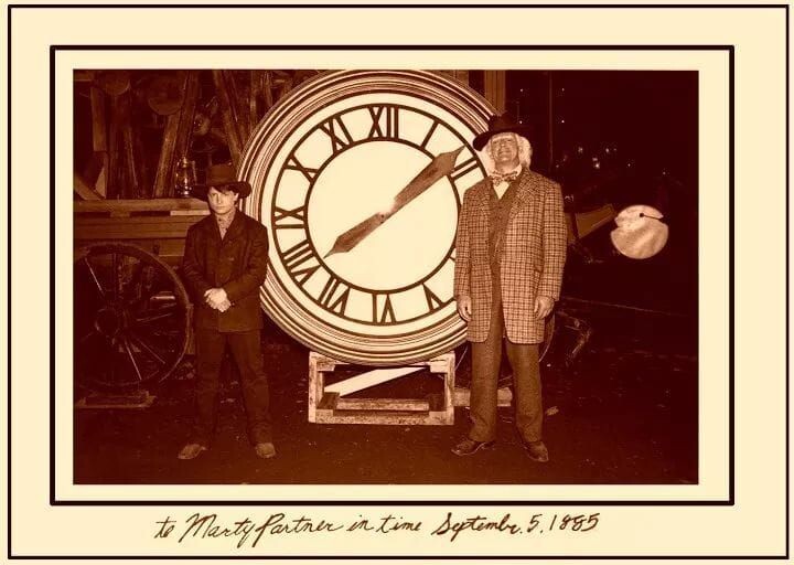 Foto dos protagonistas ao lado do relógio, com a dedicatória: To Marty, partner in time, September 5 1855