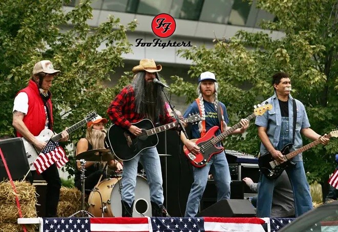 Os integrantes do Foo Fighters, com trajes caipiras, perucas e barbas falsas, com seus instrumentos, sobre um caminhão