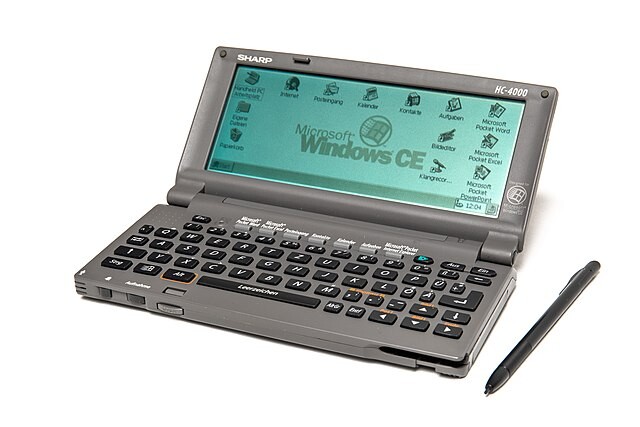 Um computador de mão rodando Windows CE, com um stylus ao lado