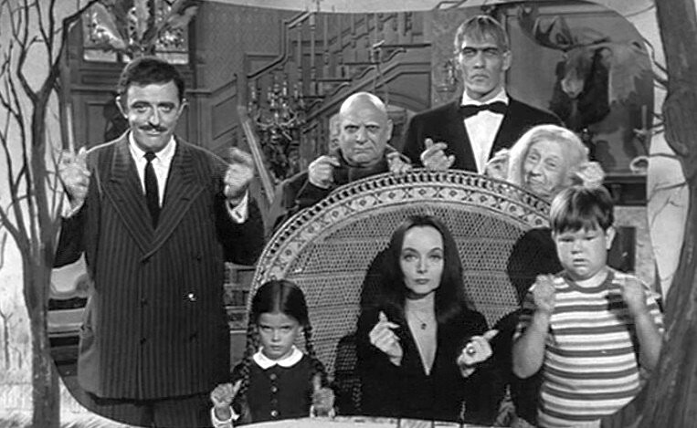 A Família Addams (incluindo o Tropeço, mas não a Mãozinha) estrala os dedos em cena da abertura da série