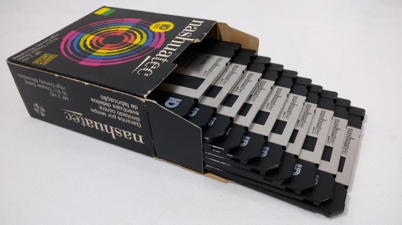 Caixa aberta de disquetes Nashuatec, com os disquetes empilhados formando degraus