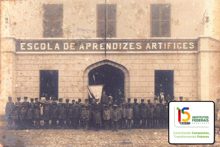 Foto antiga dos alunos perfilados em frente a uma Escola de Aprenizes Artífices, e o logo dos 15 anos dos Institutos Federais