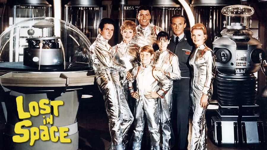 O elenco de Perdidos no Espaço, caracterizado e com trajes espaciais em foto promocional no cenário da série