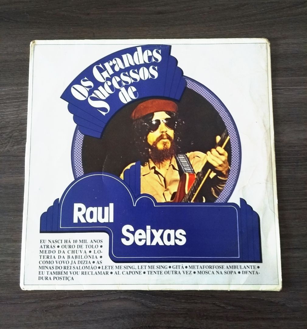 Capa do disco Os Grandes Sucessos de Raul Seixas, com Raul de boina vermelha e óculos escuros, segurando sua guitarra