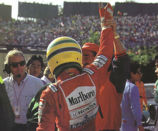 Mansell, já sem o traje de pilotagem, ergue o braço do campeão Senna em Suzuka