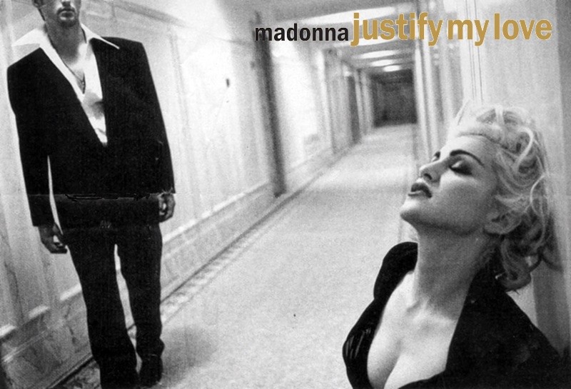 Cena do vídeo de Justify My Love. Num corredor de hotel, um homem com traje social se aproxima de Madonna, com figurino em estilo Marilyn Monroe.