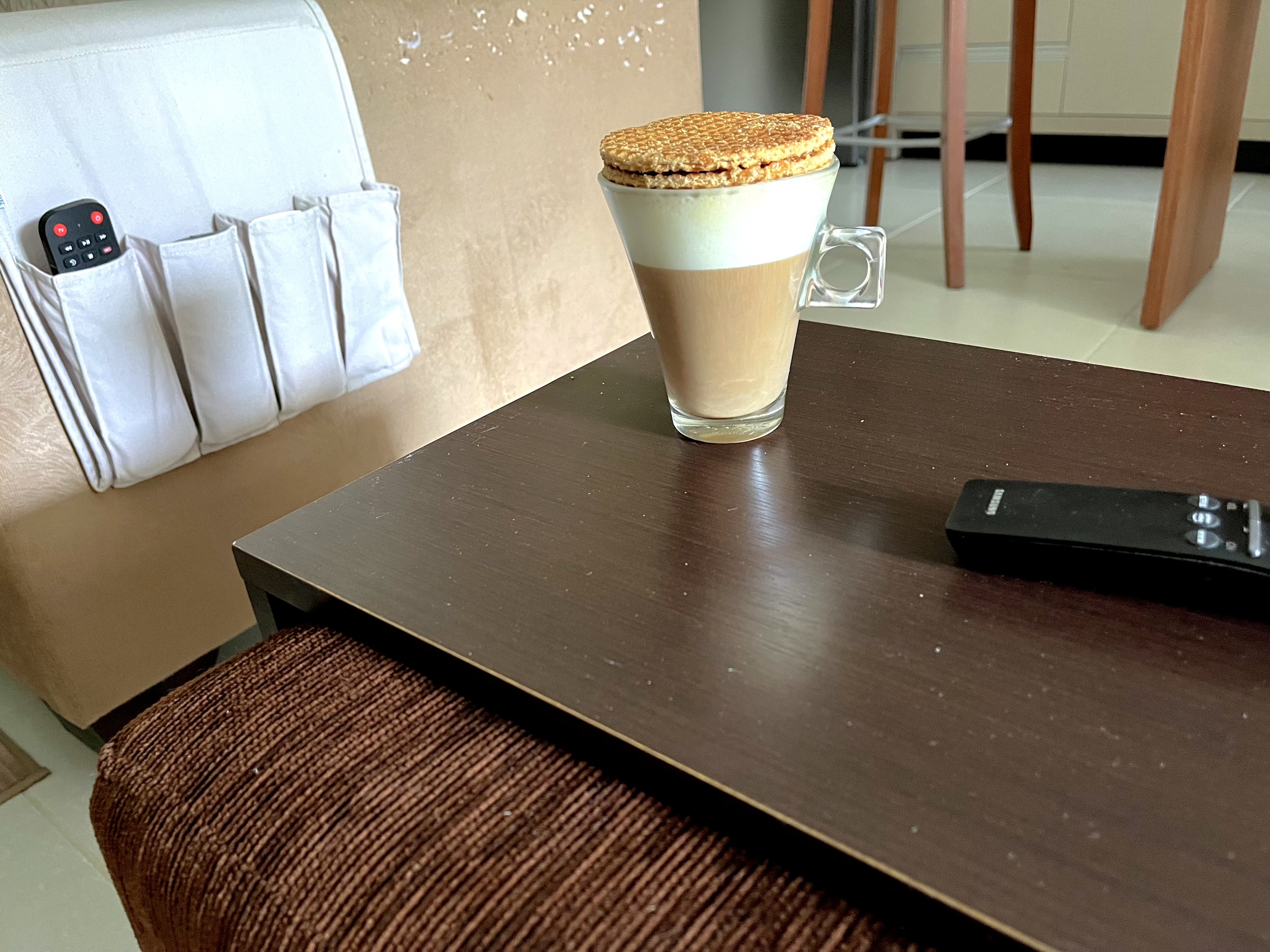 Xícara de café com leite, com dois biscoitos stroopwafel sobre ela