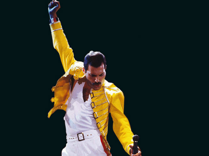 Freddie Mercury no palco em postura icônica, de roupa branca e casaco amarelo