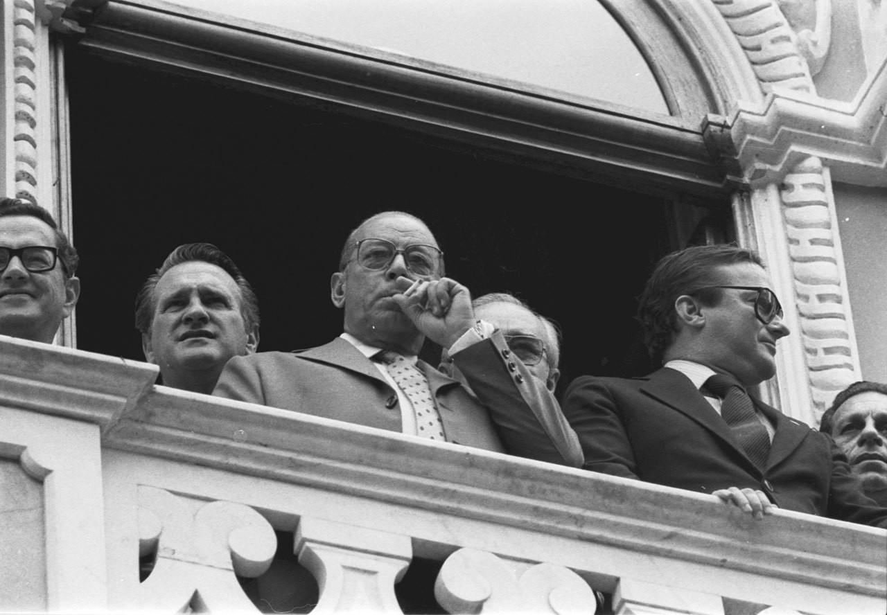 Na sacada do Palácio Cruz e Sousa e ao lado do governador de SC, João Figueiredo fuma enquanto olha para os manifestantes reunidos na praça em frente.