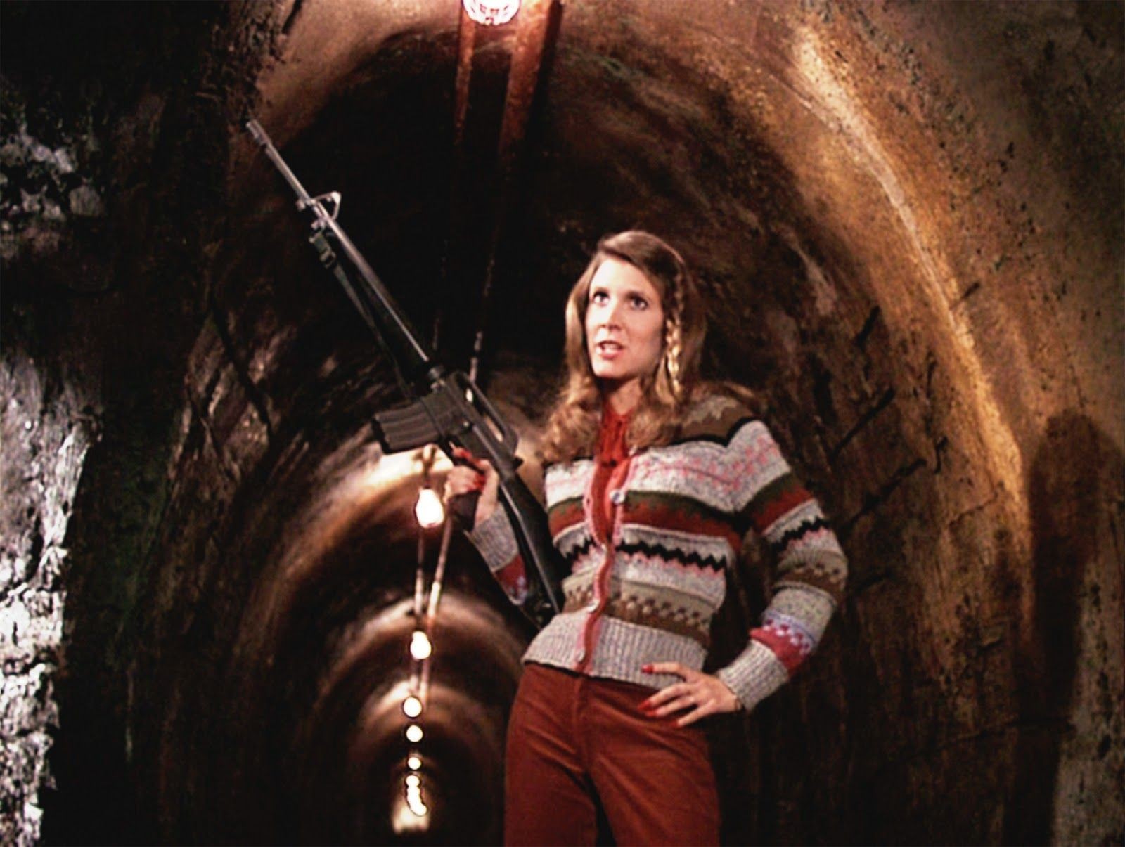 Carrie Fischer empunha um rifle em The Blues Brothers - Os Irmãos Cara-de-Pau, no Brasil.