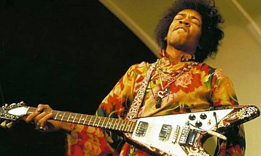 Jimi Hendrix no palco com uma guitarra Flying V