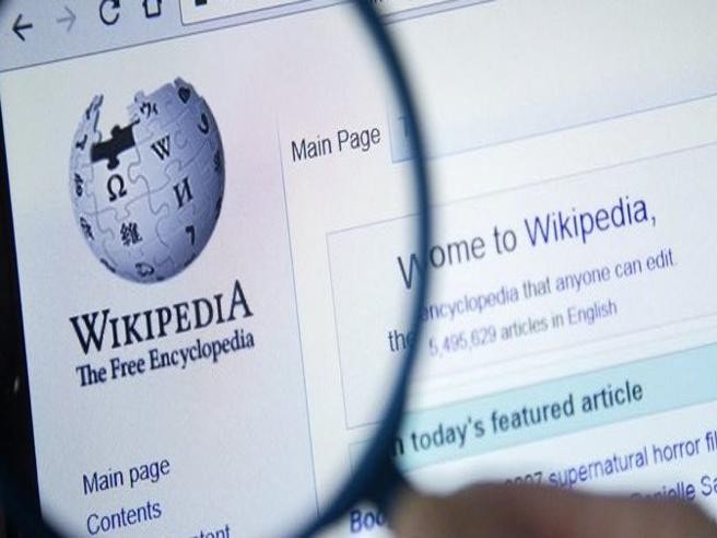 Uma lupa amplia o logotipo da Wikipedia em seu site