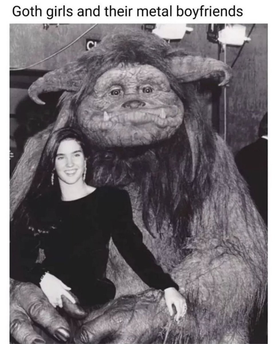 A personagem Sarah, sorrindo vestida de preto, sendo abraçada pelo monstro Ludo, do filme Labirinto