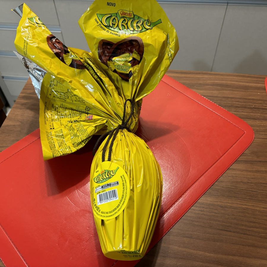 Um ovo de páscoa com embalagem amarela em cujo rótulo se lê: Novo Garoto Caribe com flocos de banana