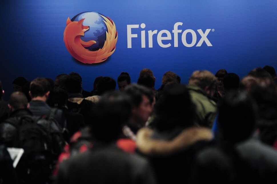 Público em um auditório decorado com a marca da Mozilla.