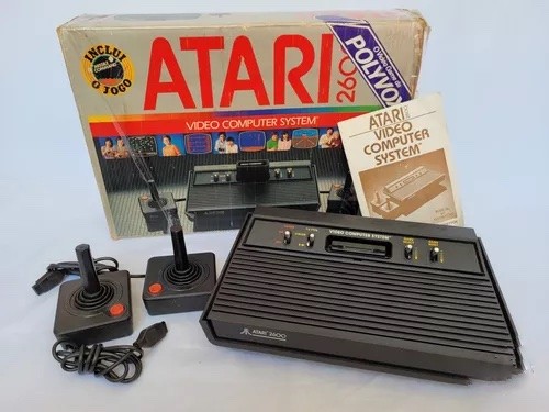 Um Atari 2600 da Polyvox com caixa, 2 controles e o manual impresso que acompanhava.