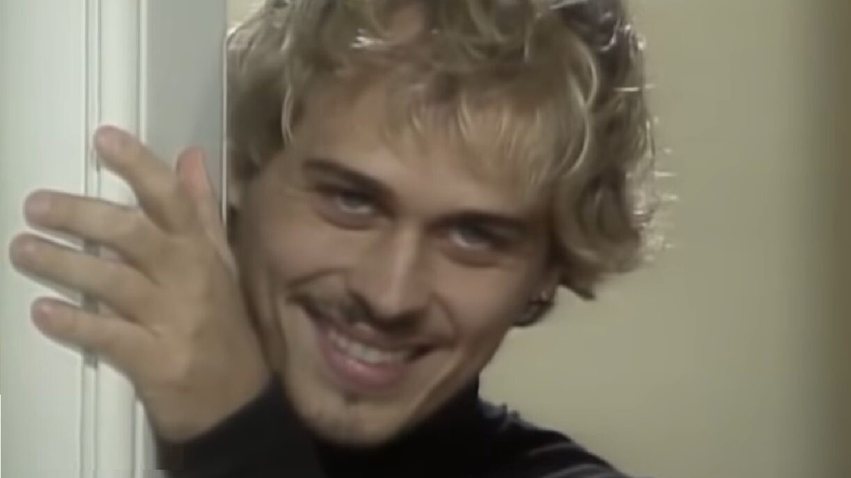 O personagem Alexandre, sorrindo e em close.