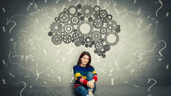Foto de mulher sorrindo, com um desenho de um cérebro formado por engrenagens, acima dela <br> 