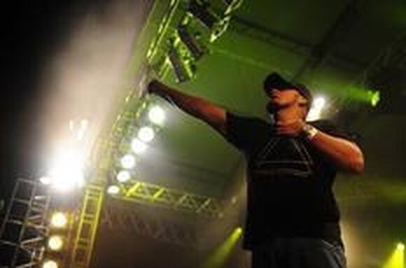 Digão, o vocalista dos Raimundos, de braço erguido no palco