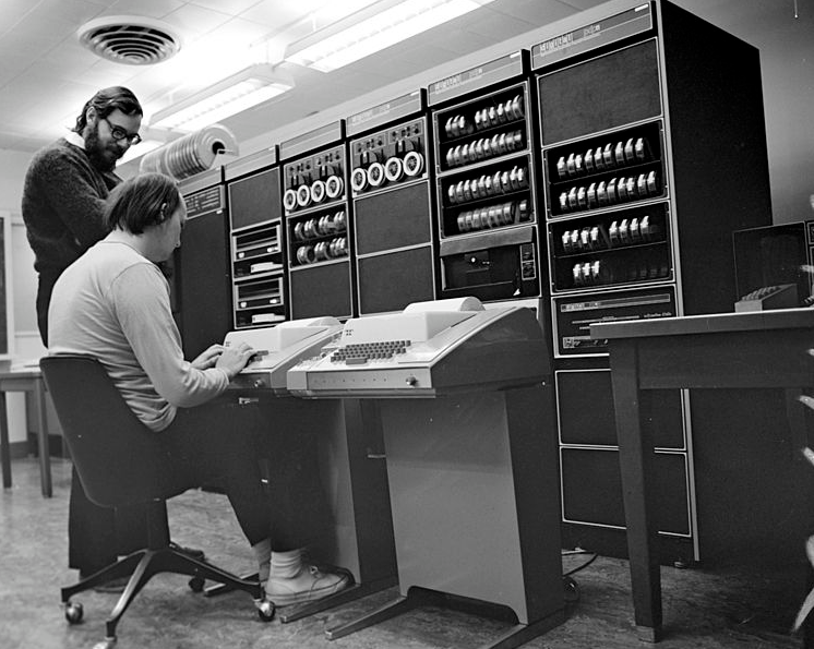 Ken Thompson (sentado) e Dennis Ritchie (em pé) junto a um computador PDP-11