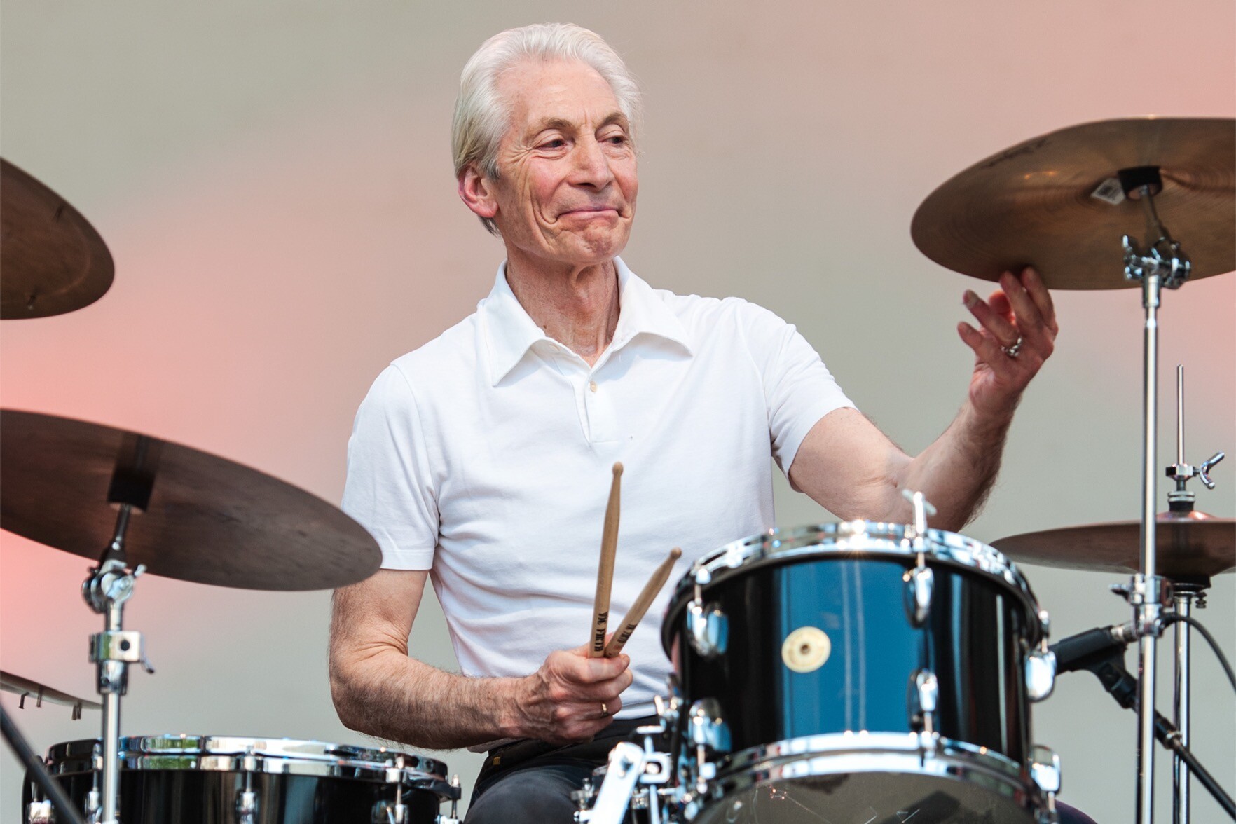 Charlie Watts sorri junto à sua bateria
