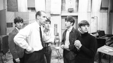 George Martin, de gravata e sem paletó, e os jovens Beatles