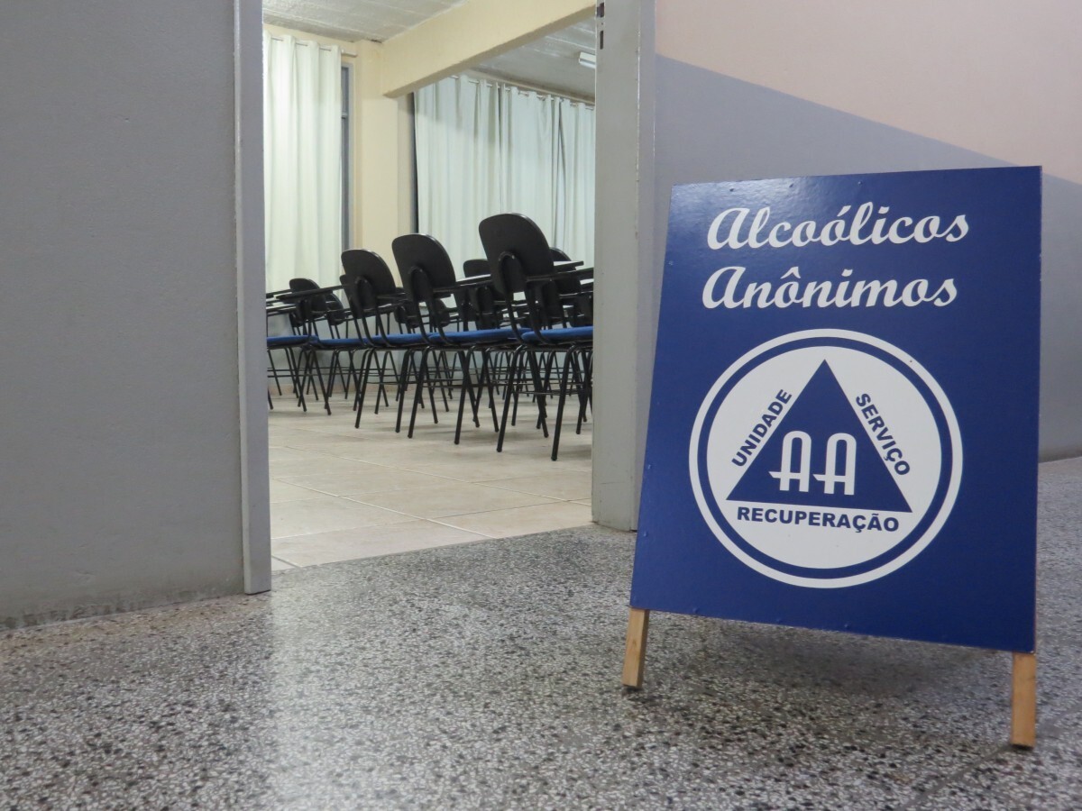 Exterior de uma sala com cartaz dos Alcoólicos Anônimos
