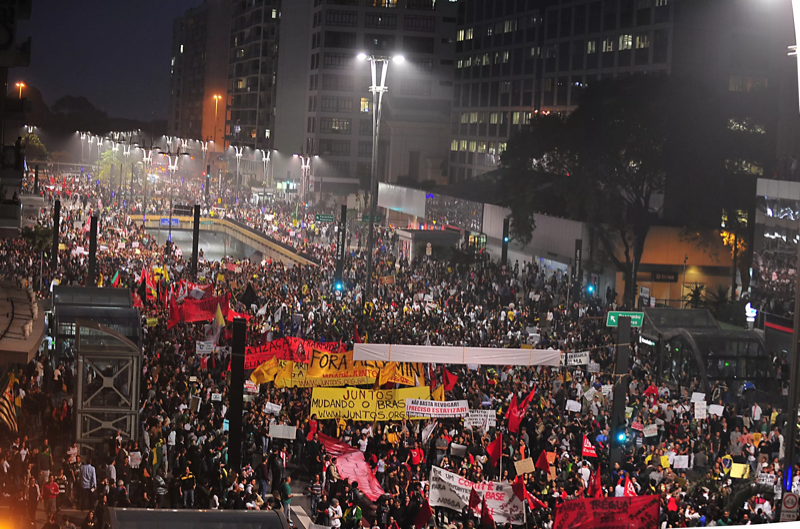 Manifestantes com faixas tomando uma rua durante os chamados Protestos de Junho
