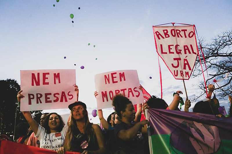 Manifestantes em frente ao STF em 2018, segurando cartazes que dizem: “Nem presas, nem mortas - aborto legal já”