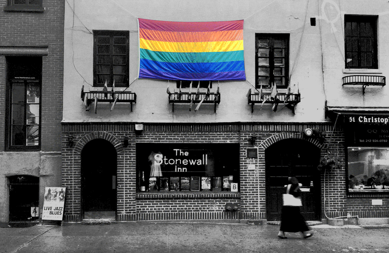 Bandeira do orgulho, colorida, sobre foto em preto e branco do Stonewall Inn.