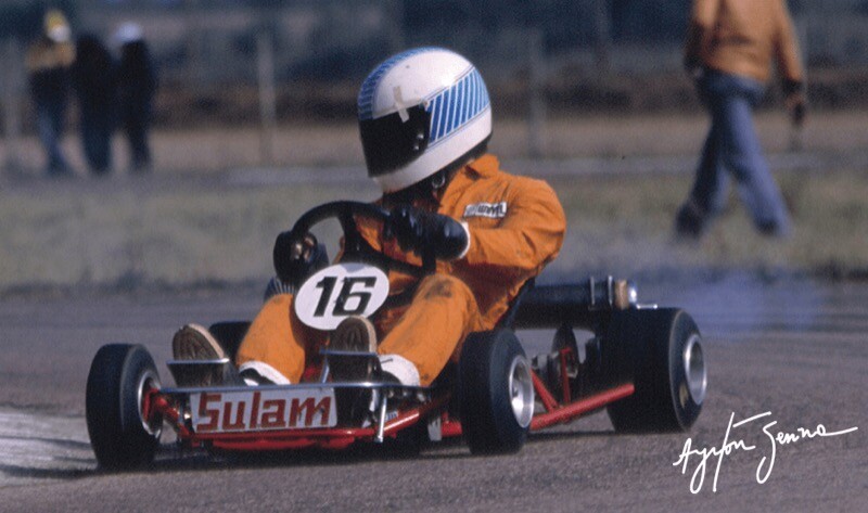 Senna, de macacão amarelo e capacete azul e branco, no kart número 16
