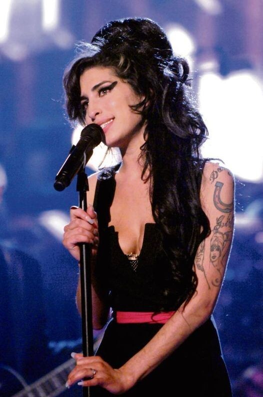 Amy Winehouse sorri no palco
